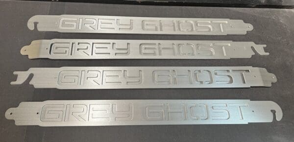 Four metal name plates sitting on top of a table