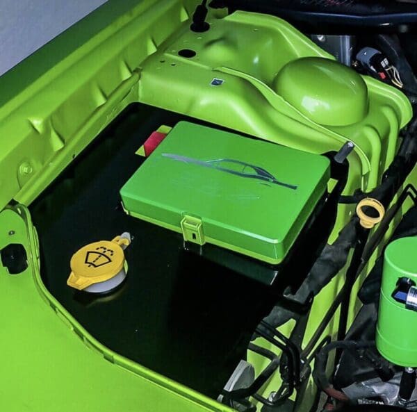 The engine compartment of a green car with its hood open