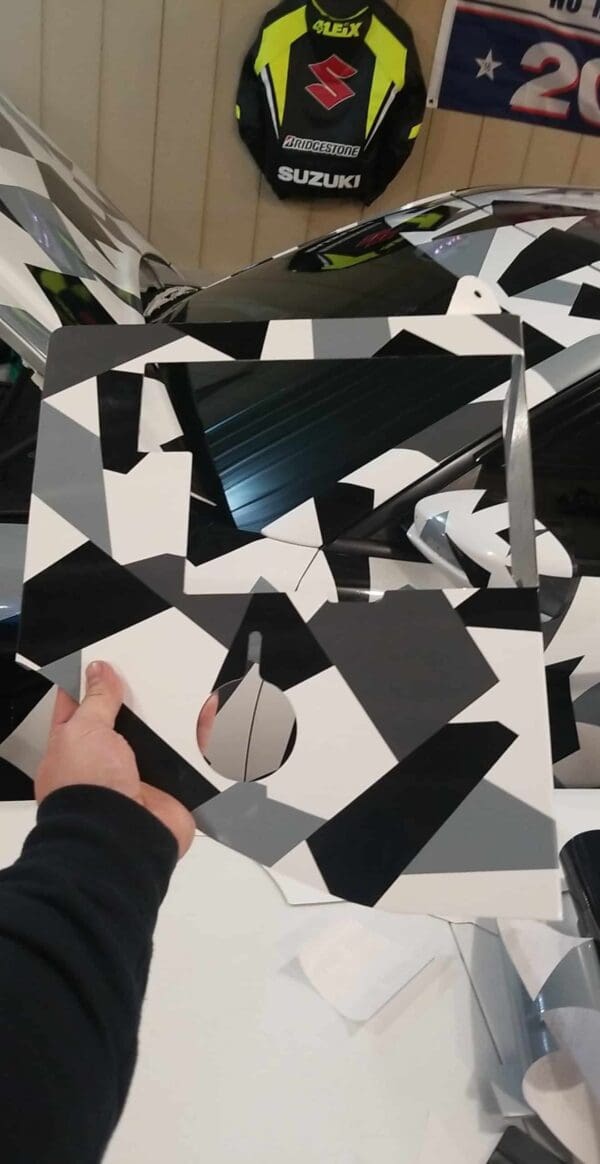 A person cutting out a piece of black and white paper