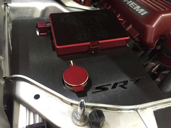 The engine of a car featuring a red cover with "HEMI" and "SRT" branding.