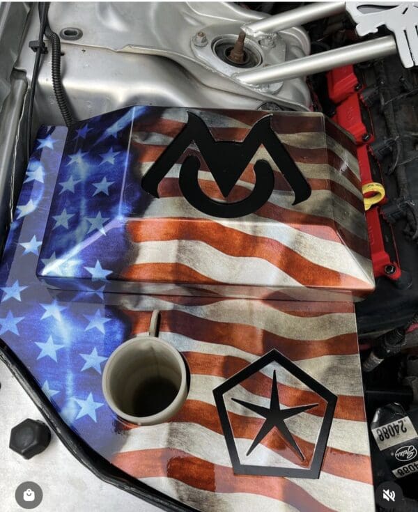 A close up of a car engine with an american flag