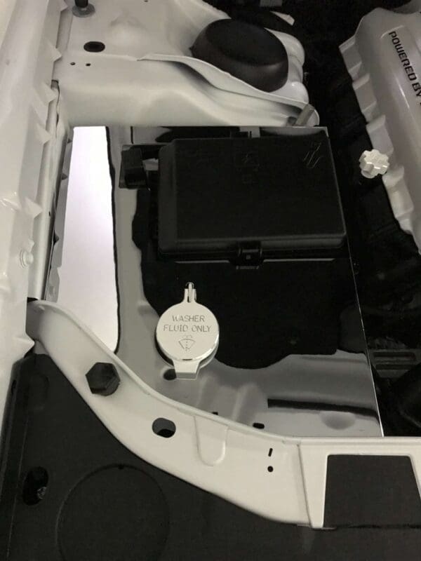 Car engine compartment with a washer fluid cap labeled "Washer Fluid Only."