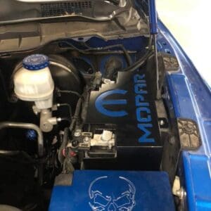 The engine of a blue car with a skull on it