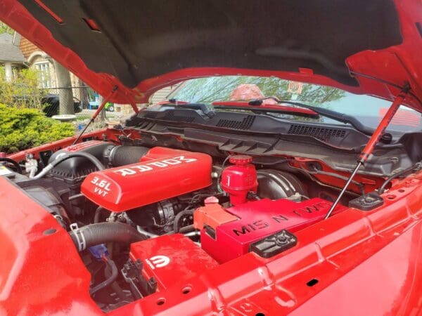 The engine compartment of a red sports car