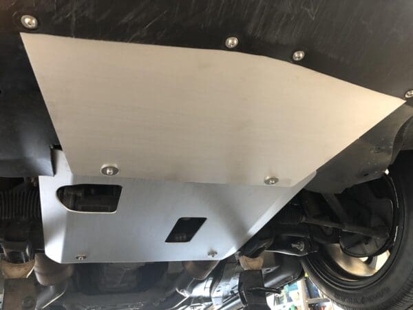 Undercarriage skid plate installed on a vehicle for protection.