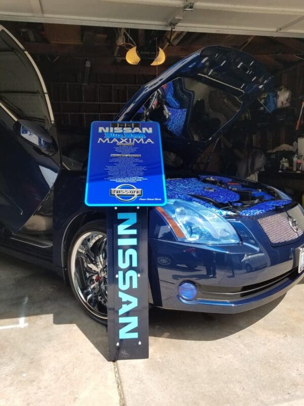 A blue car with its hood open in a garage