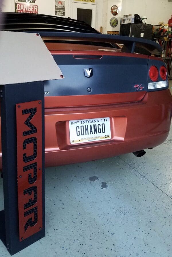 Rear view of a red car with the personalized license plate 'GOMANGO'.