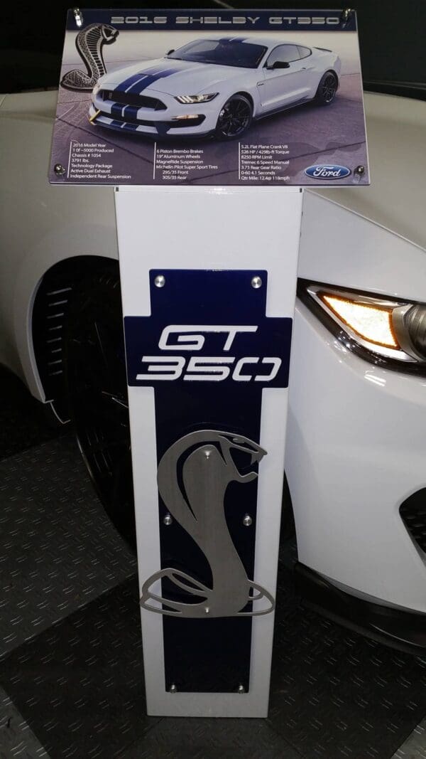 A white sports car is on display in a showroom