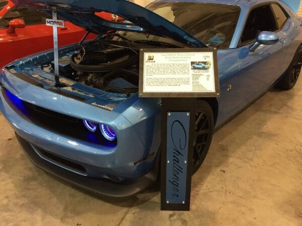 A blue sports car with its hood open