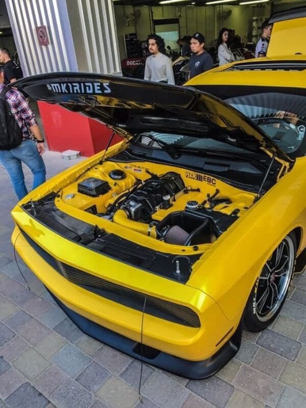 A yellow sports car with its hood open