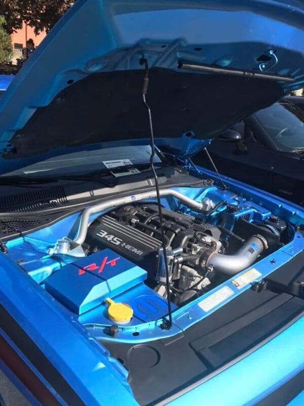 The engine compartment of a blue car with its hood open