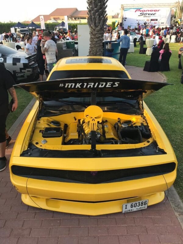 A yellow sports car with its hood open