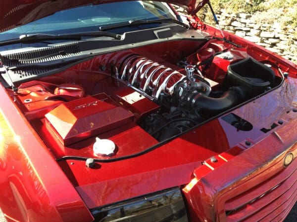 A red sports car with its hood open