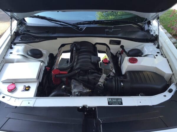 The engine compartment of a car with its hood open, showcasing a clean and organized layout.