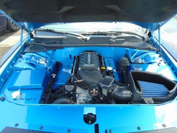 The engine compartment of a red car with its hood open