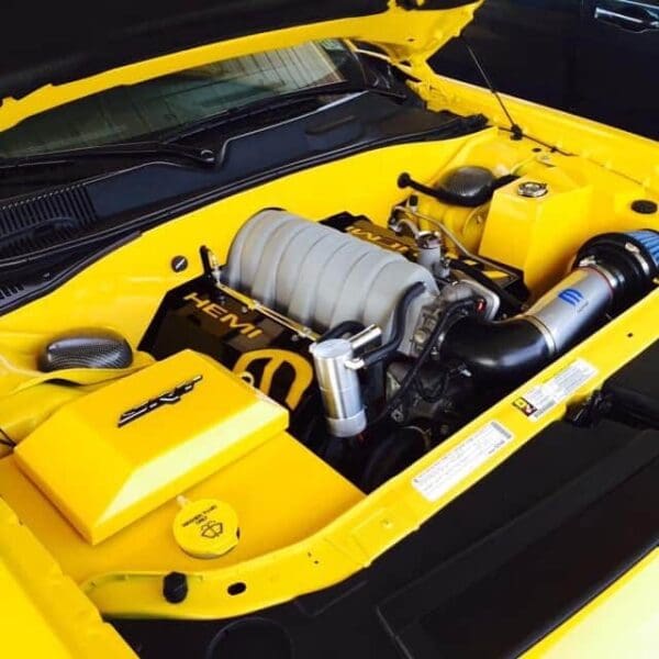 A yellow sports car with its hood open