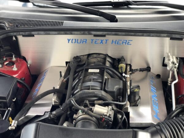 Car engine compartment with the hood open, featuring a HEMI engine and a customizable panel labeled "YOUR TEXT HERE."