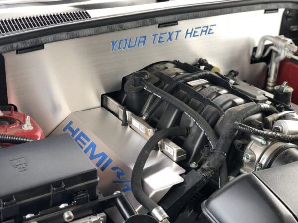 Close-up of a car engine with the hood open, featuring "HEMI R/T" and "YOUR TEXT HERE" in blue lettering.