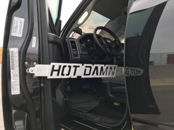 A black truck with a sign that says hot damn on it