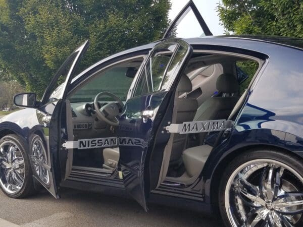 A blue car with its door open on the side of the road