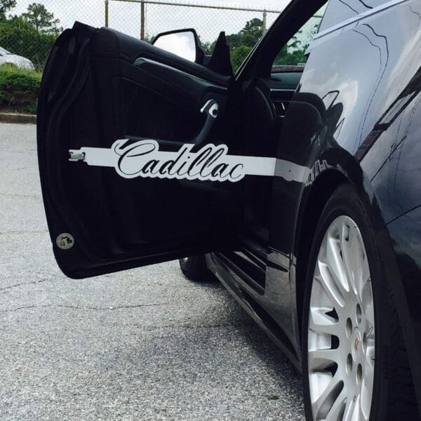 A black car with its door open with the word cadillac on it