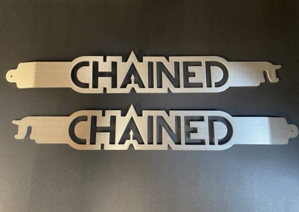 Two metal signs that say chained and chained