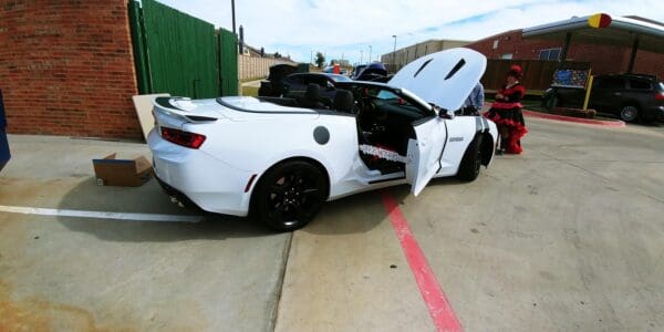 A white sports car parked in a parking lot