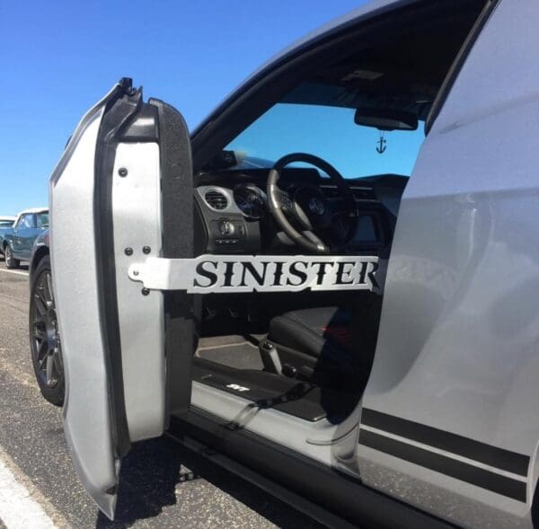 A silver van with the door open on the side of the road