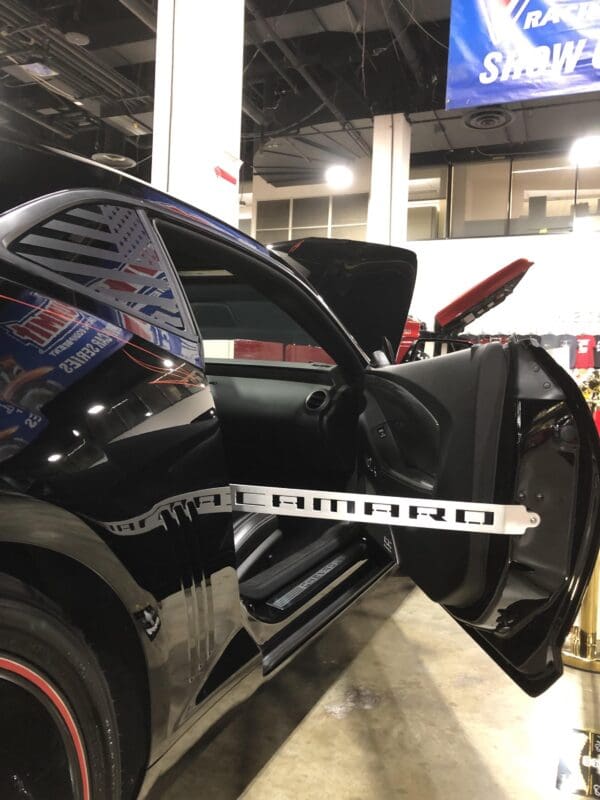 A car parked in a showroom with its door open