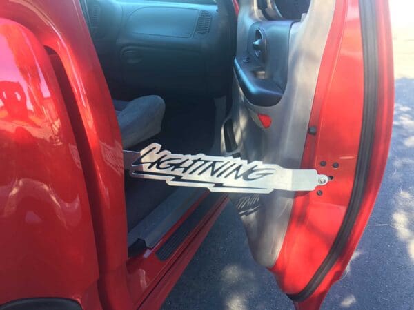 A red car with a license plate that says lightning