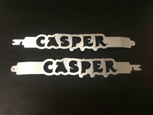 A pair of laser cut name tags on a black surface