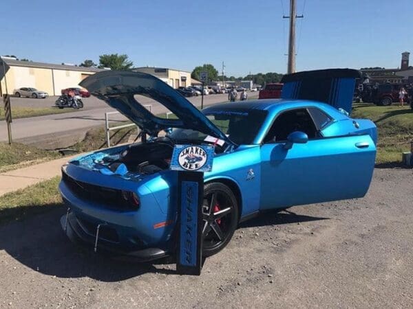 A blue sports car with its hood open