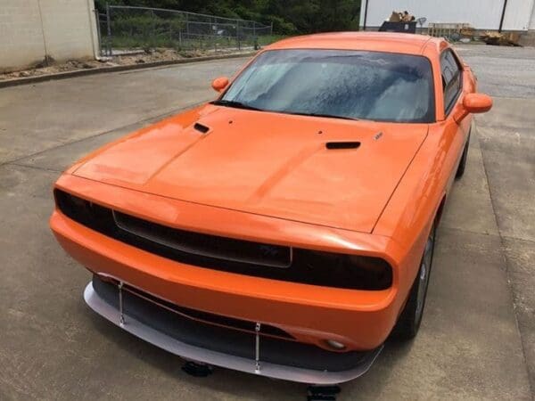 An orange dodge charger parked in a parking lot