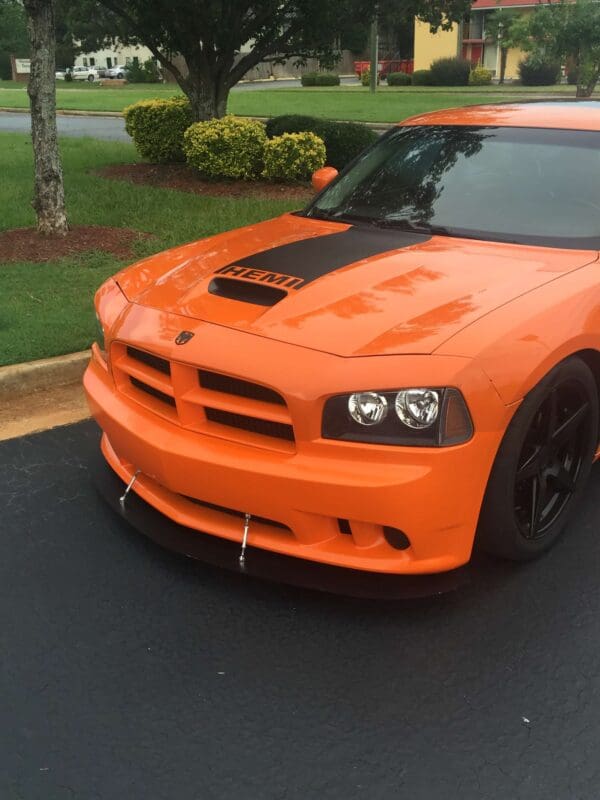 An orange dodge charger parked in a parking lot