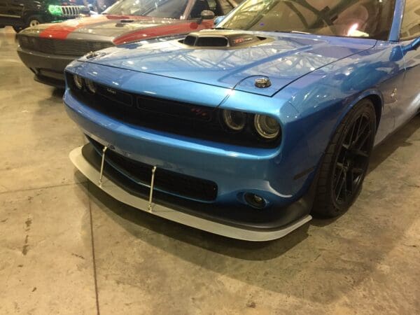 A blue car parked in a garage next to other cars