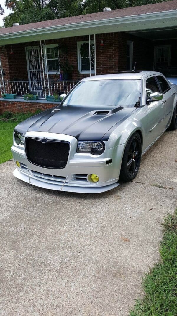 A silver car parked in front of a house