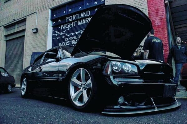 A black sports car with its hood open