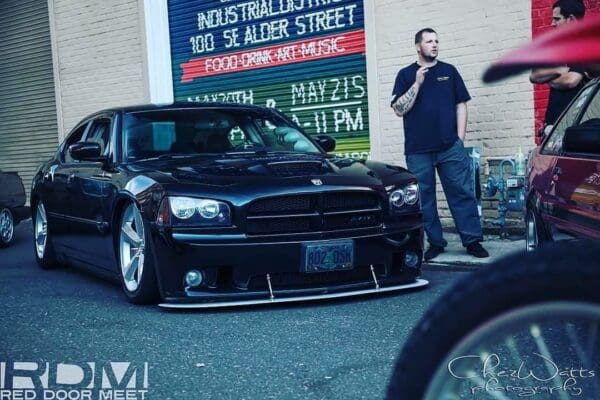 A man standing next to a black car