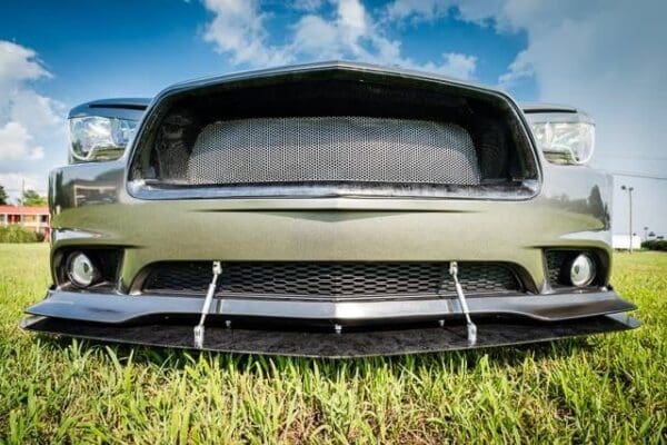 The front end of a car parked in the grass