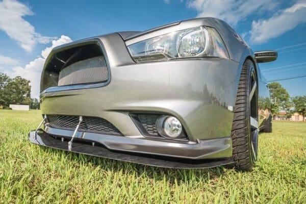 A silver car parked in a grassy field