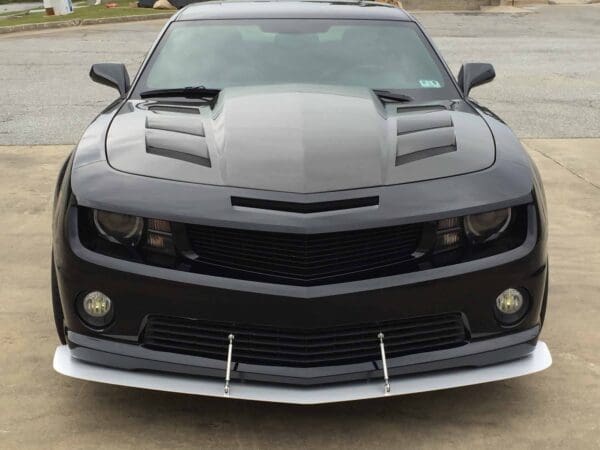 The front end of a black car parked in a parking lot