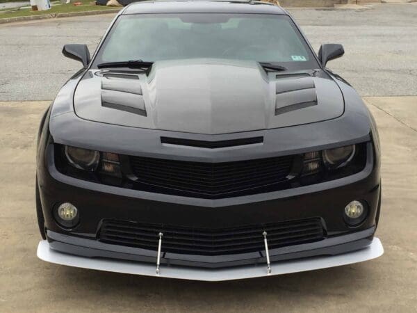 The front view of a sleek black car parked in a parking lot.