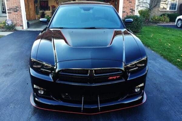 A black car parked in front of a house