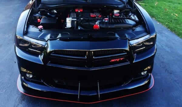 A black dodge charger with its hood open