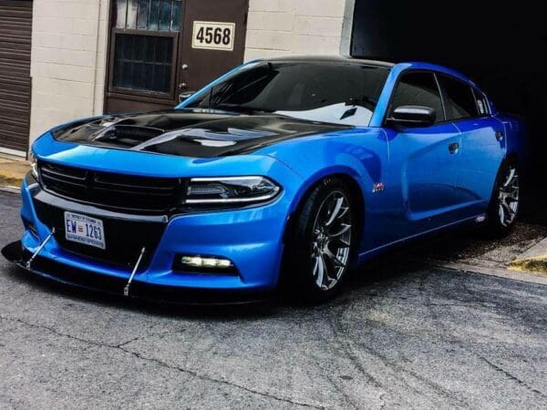 A blue car parked in front of a garage