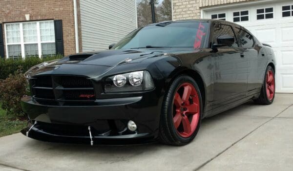 A black car parked in front of a house