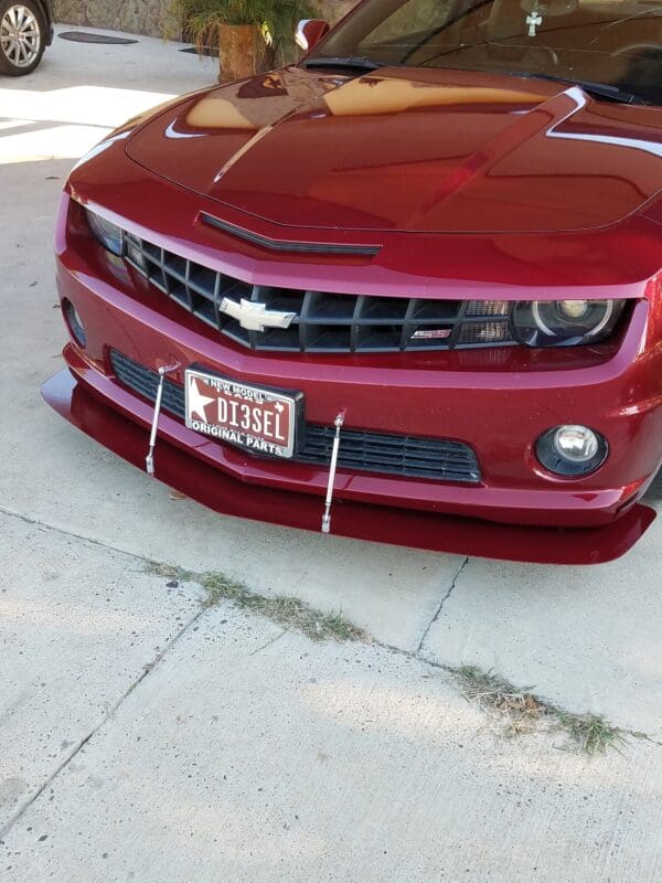 A red chevrolet camaro parked in a driveway