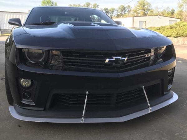 A black Chevrolet Camaro ZL1 parked in a parking lot, showing the front grille and emblem.