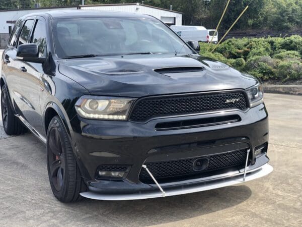 A black Dodge SUV parked in a lot, featuring a sleek design and prominent front grille.