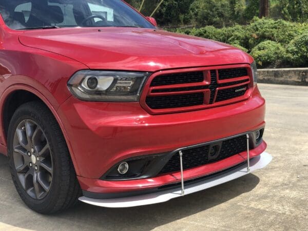 A red Dodge truck parked in a lot, featuring alloy wheels and a prominent front grille.